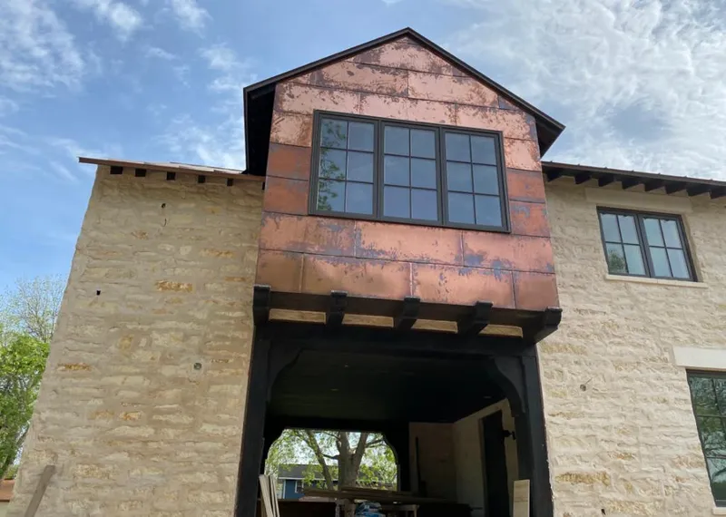 Copper metal panel facade on a stone building for Skylight Installation in Badger