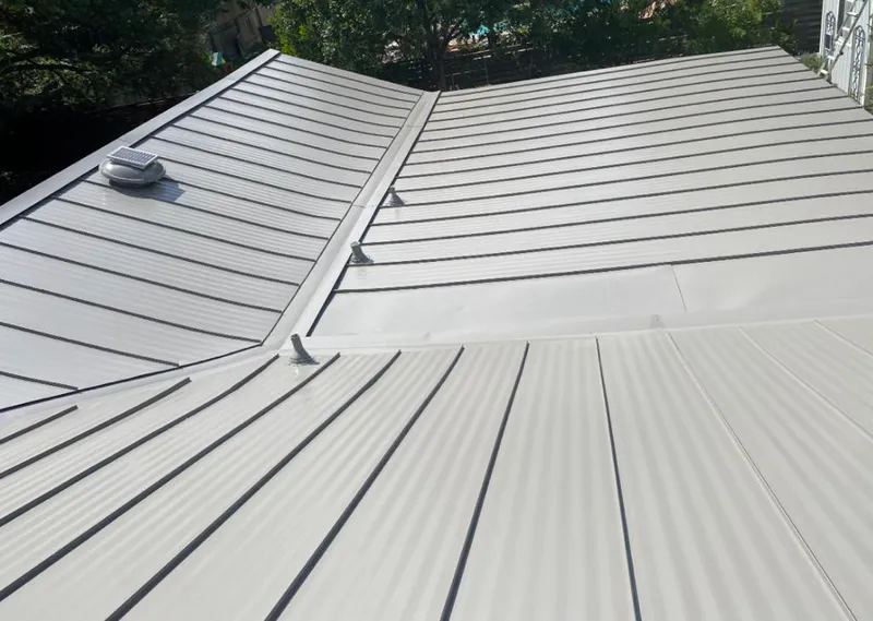 Solar attic fan installed on a metal roof for Roof Ventilation in Badger